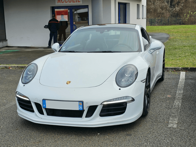 Porsche 911 blanche devant l'accueil du centre