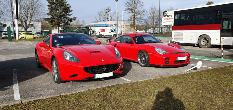 Ferrari California et Porsche rouges sur le parking